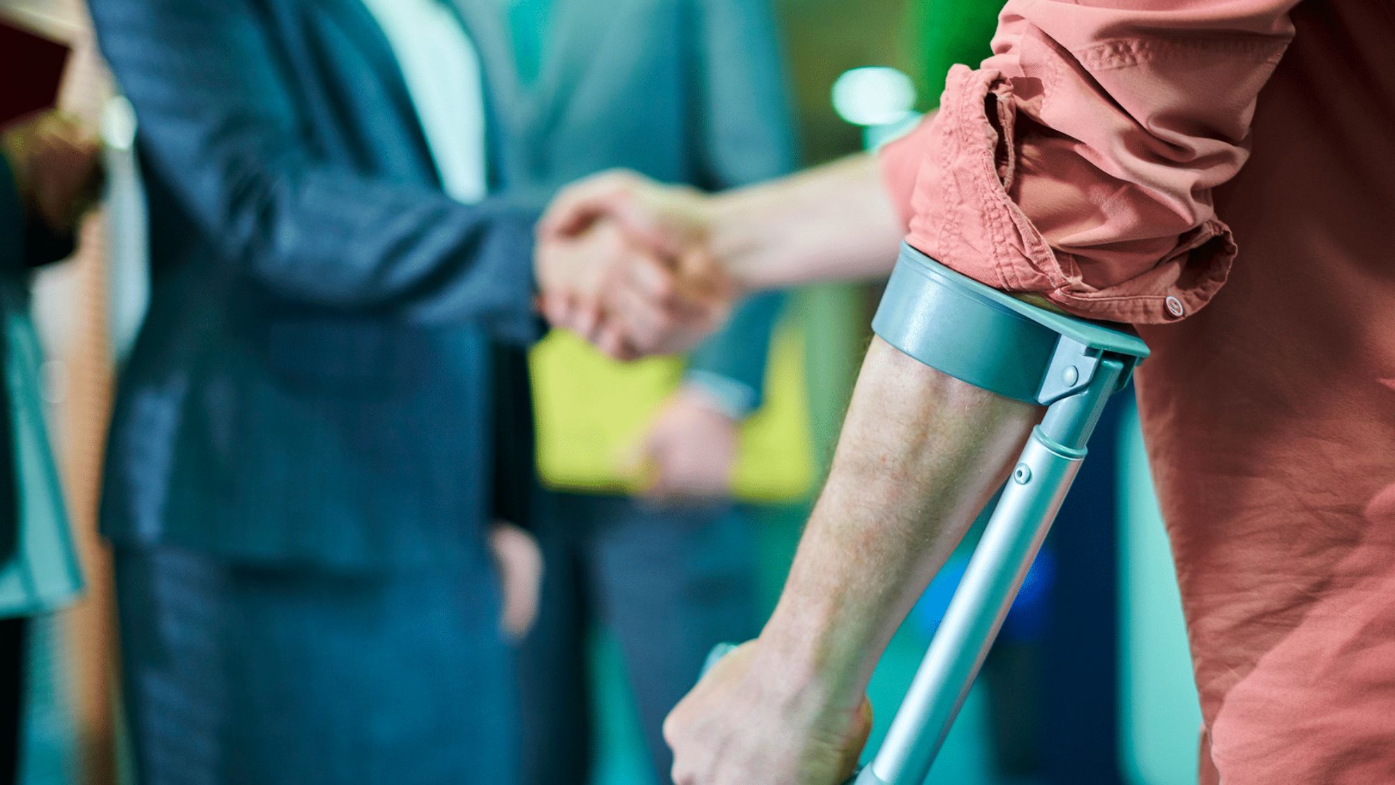 A man with crutches shaking hands with a lawyer regarding legal support in accident claims