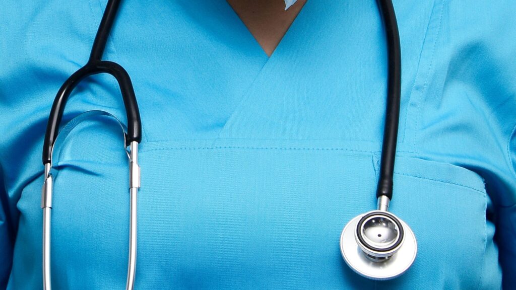 Health workers in the UK wearing blue medical scrubs